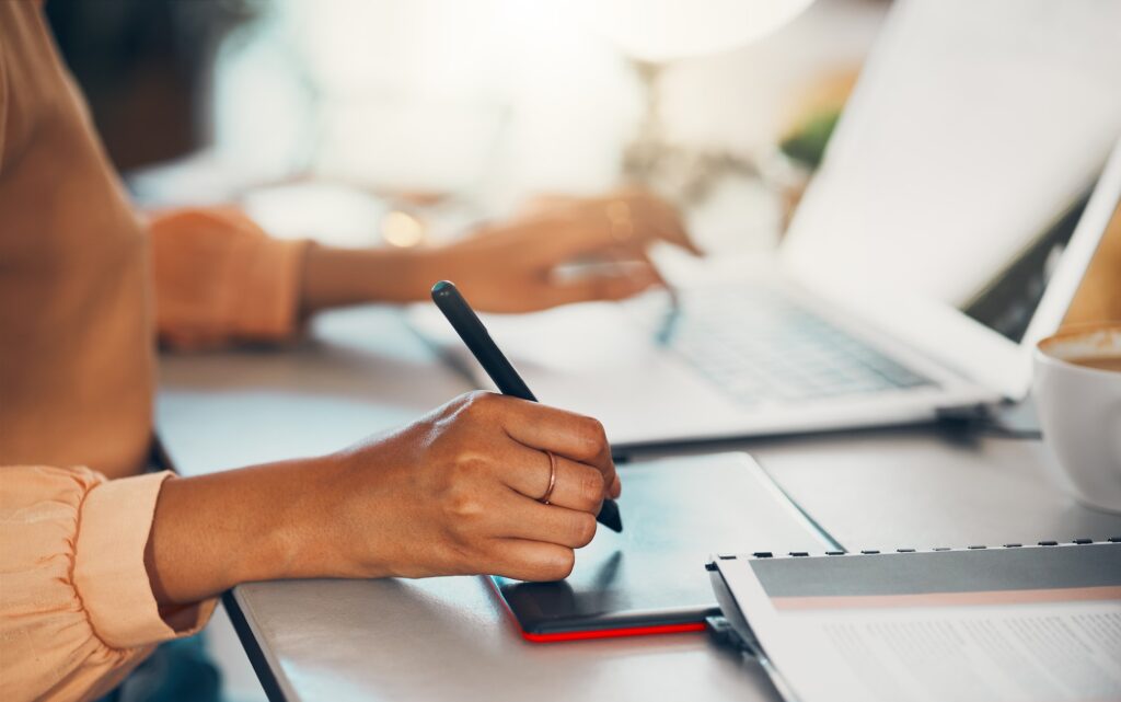 TUDO o que Você Deve Saber Antes de INVESTIR no INSTAGRAM da Sua Empresa 2 Designer gráfico escrevendo notas no tablet online, digitando no laptop e planejando uma tarefa trabalhando remotamente