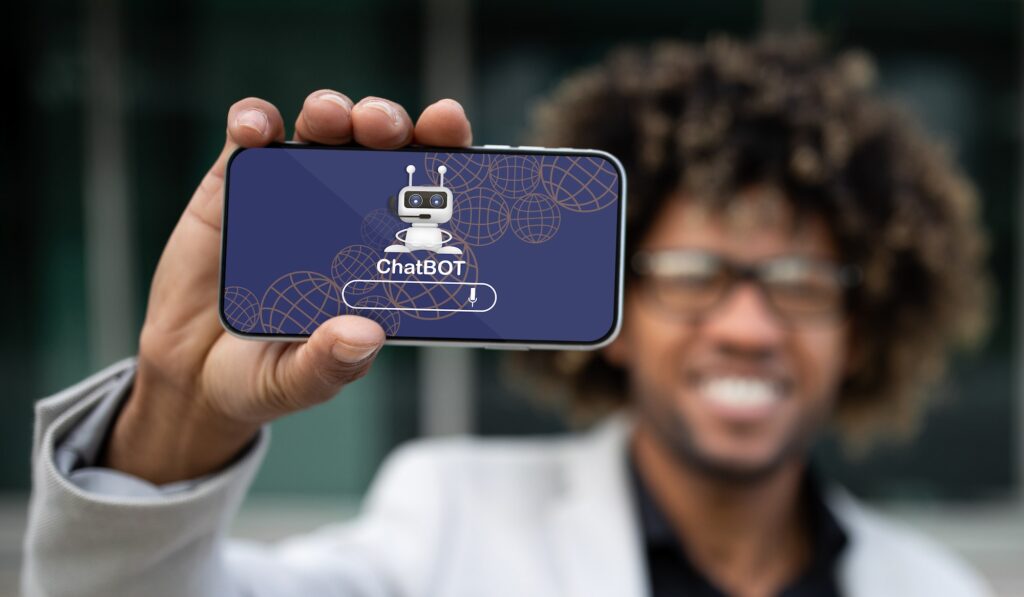 Empresário afro-americano positivo mostrando telefone com chatbot